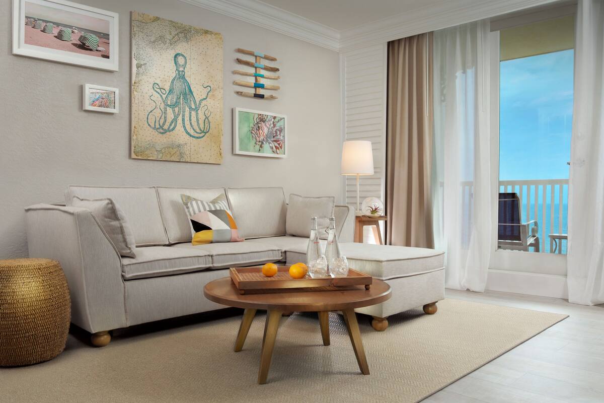A living room with a sofa, a coffee table, and artwork on the wall.