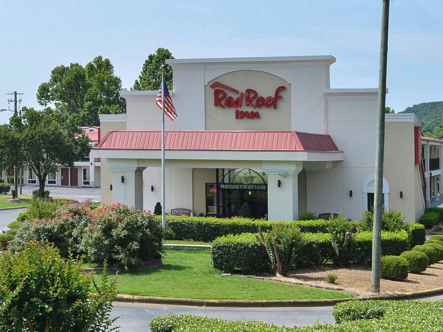 A Red Roof Inn with a red roof and American flag.