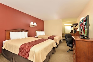 A hotel room with two beds, a desk with a television, and a mirror. - Red Roof Inn Dalton (Dalton)
