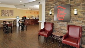 Hall del Red Roof Inn con poltrone in pelle, angolo cottura e zona pranzo.