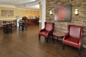 Vestíbulo de Red Roof Inn con sillas de cuero, una zona de cocina y un comedor.