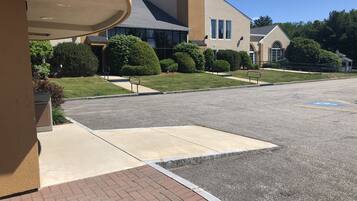 A parking lot with a handicapped parking space, a building with a modern design, and well-maintained landscaping.