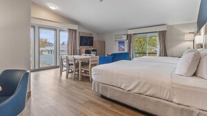 A hotel room with a large bed, a desk with a chair, a TV, and a view of the outside. - Best Western Plus The Inn at Hampton (Hampton)