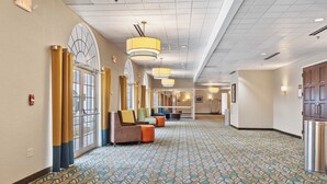 A hotel lobby with a patterned carpet, large windows with curtains, and seating areas. - Best Western Plus The Inn at Hampton (Hampton)