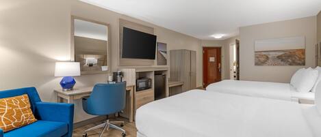 Quarto de hotel com uma cama, uma escrivaninha com cadeira, uma televisão e um quadro na parede.