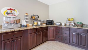 Una cocina con estación de desayuno, que incluye cafetera, tostadora y diversos alimentos.