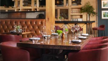 A restaurant with a wooden bar and booth seating.