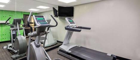 A gym with treadmills, elliptical machines, and a stationary bike.