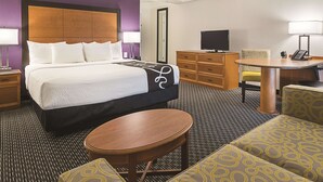 Une chambre d’hôtel équipée d’un lit, d’un bureau, d’une chaise, d’une télévision et d’un téléphone.
