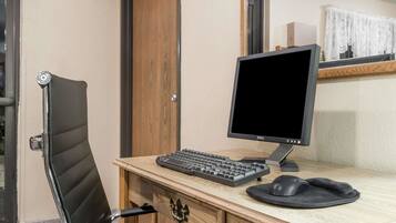 Un bureau en bois avec un écran, un clavier et une souris de la marque Dell.