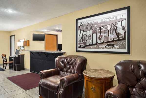 A lobby with leather armchairs, a reception desk, and a framed welcome sign.