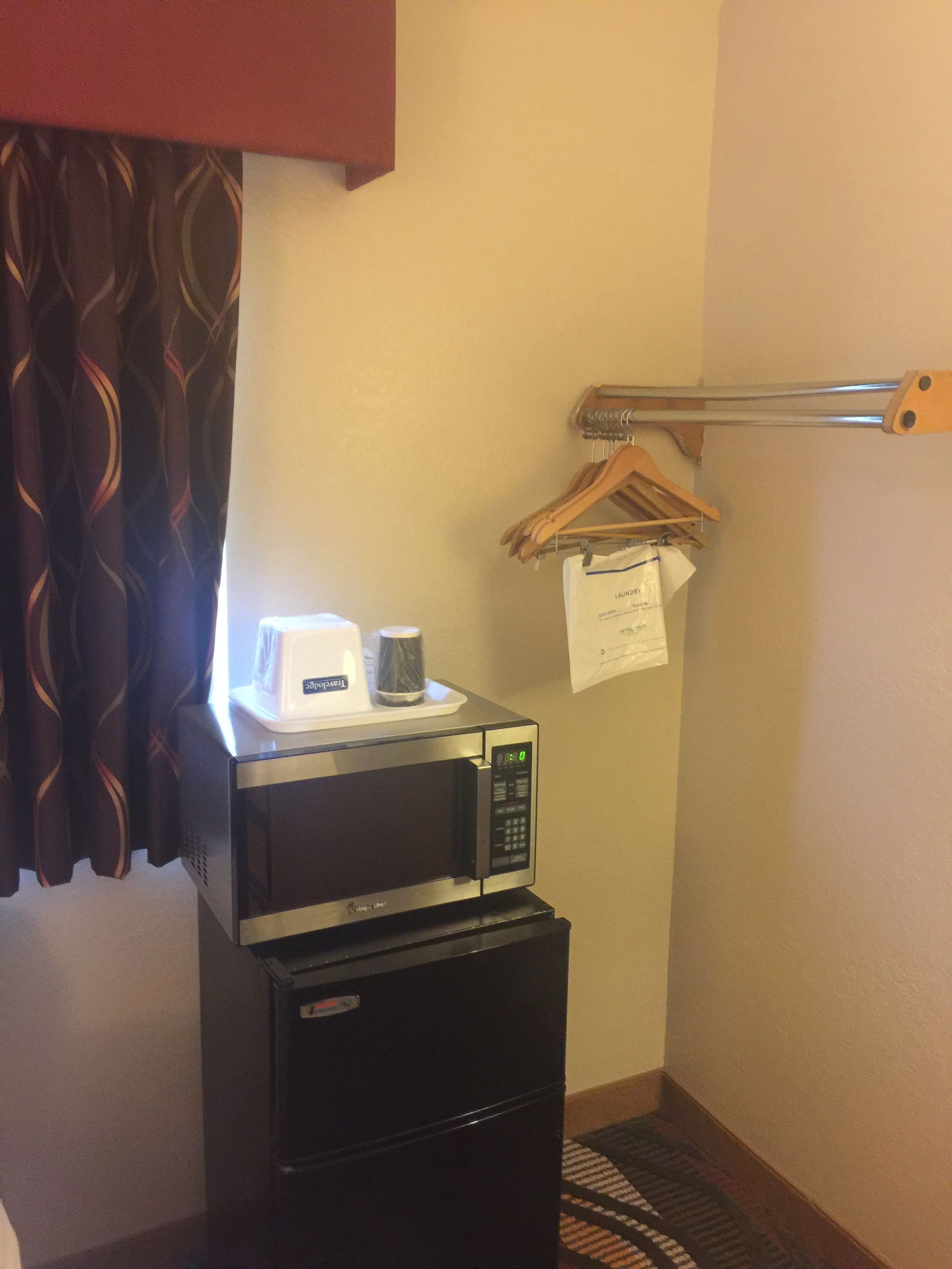 A compact kitchenette with a microwave, a coffee maker, and a small refrigerator.