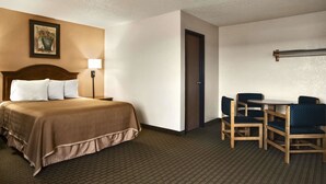 Una habitación de hotel con una cama, un escritorio y dos sillas.