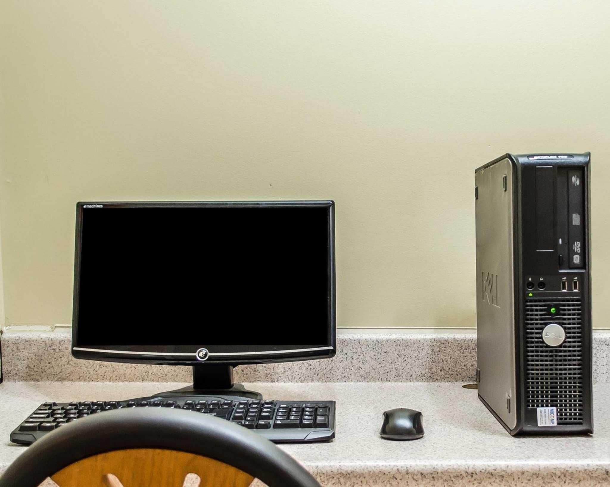 Una computadora de escritorio con monitor, teclado y ratón sobre una encimera.