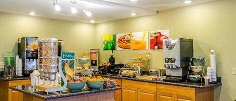 A breakfast bar with a coffee machine, juice dispenser, and cereal containers.