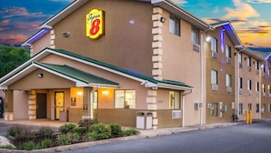 A hotel with a 'Super 8' sign, a green awning, and a row of windows on the side. - Super 8 by Wyndham Harrisonburg (Harrisonburg)