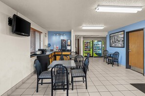 A restaurant with a bar area, seating, and a vending machine.
