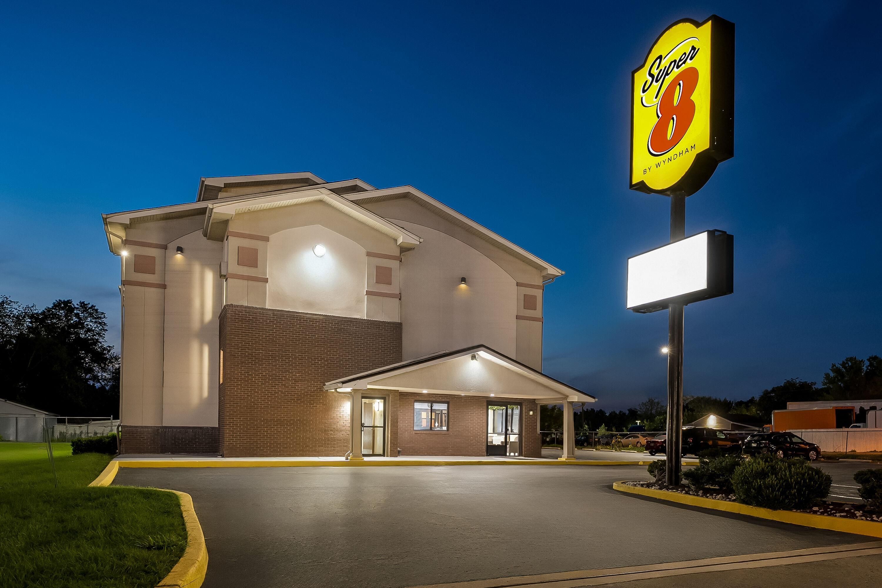 A Super 8 hotel with a brick facade, a covered entrance, and a large illuminated sign.