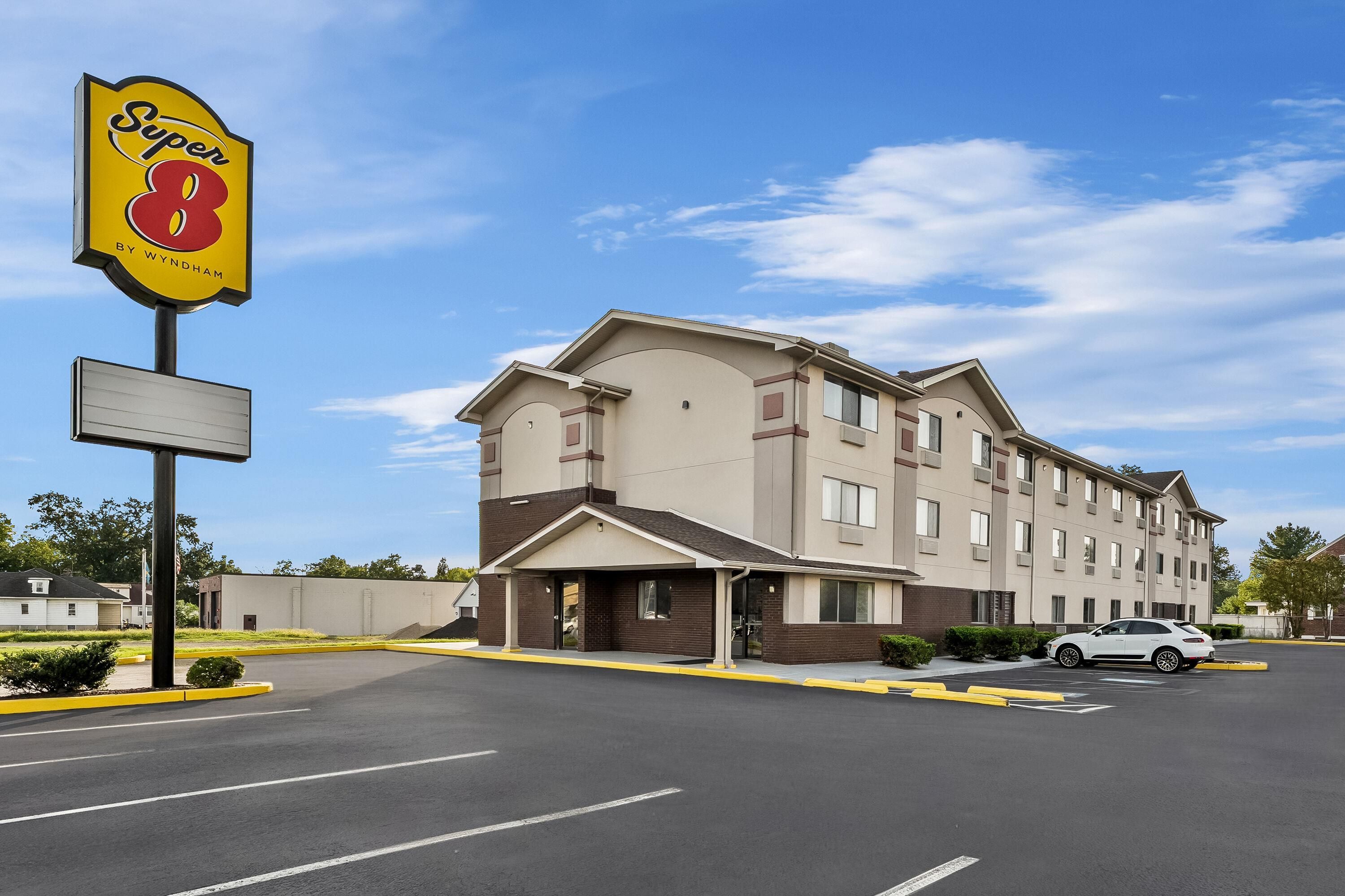 A Super 8 hotel with a parking lot and a building with multiple windows and a flat roof.