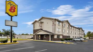 Un hotel Super 8 con estacionamiento y un edificio de varios pisos y techo plano.
