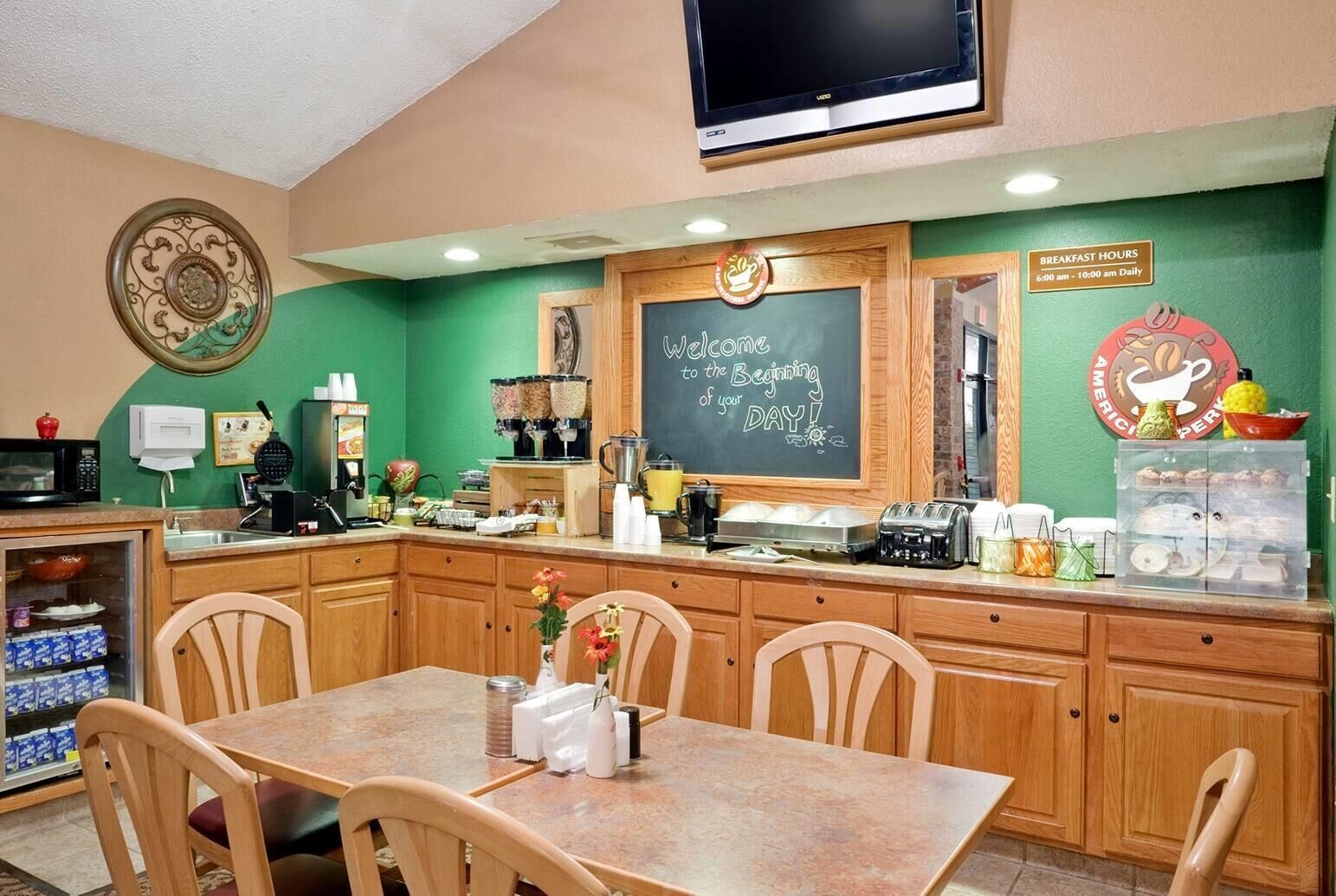 Un espace réservé au petit-déjeuner, avec un tableau noir, un téléviseur et un coin café.
