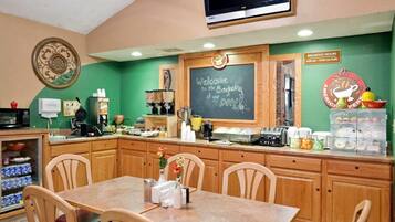 A breakfast area with a chalkboard sign, a television, and a coffee station.