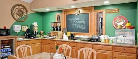 Un espace réservé au petit-déjeuner, avec un tableau noir, un téléviseur et un coin café.