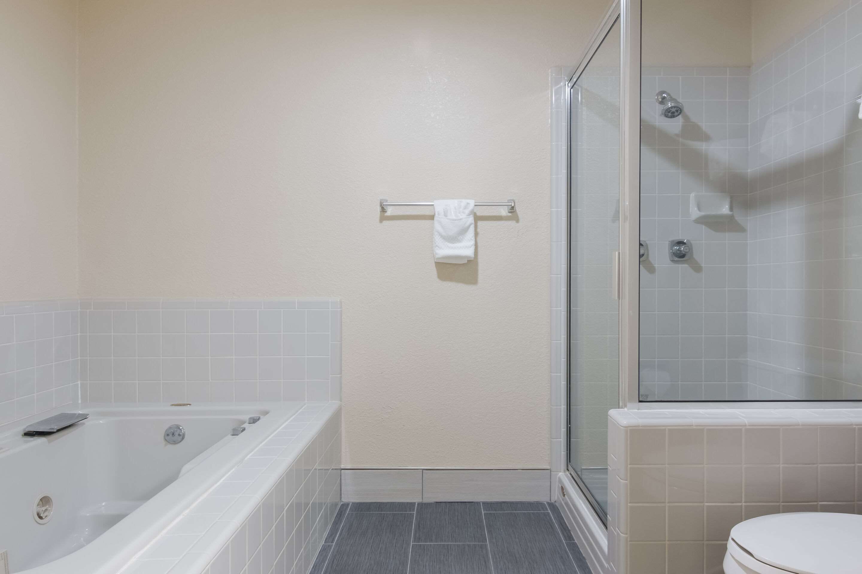 A bathroom with a bathtub, a toilet, and a glass shower enclosure.