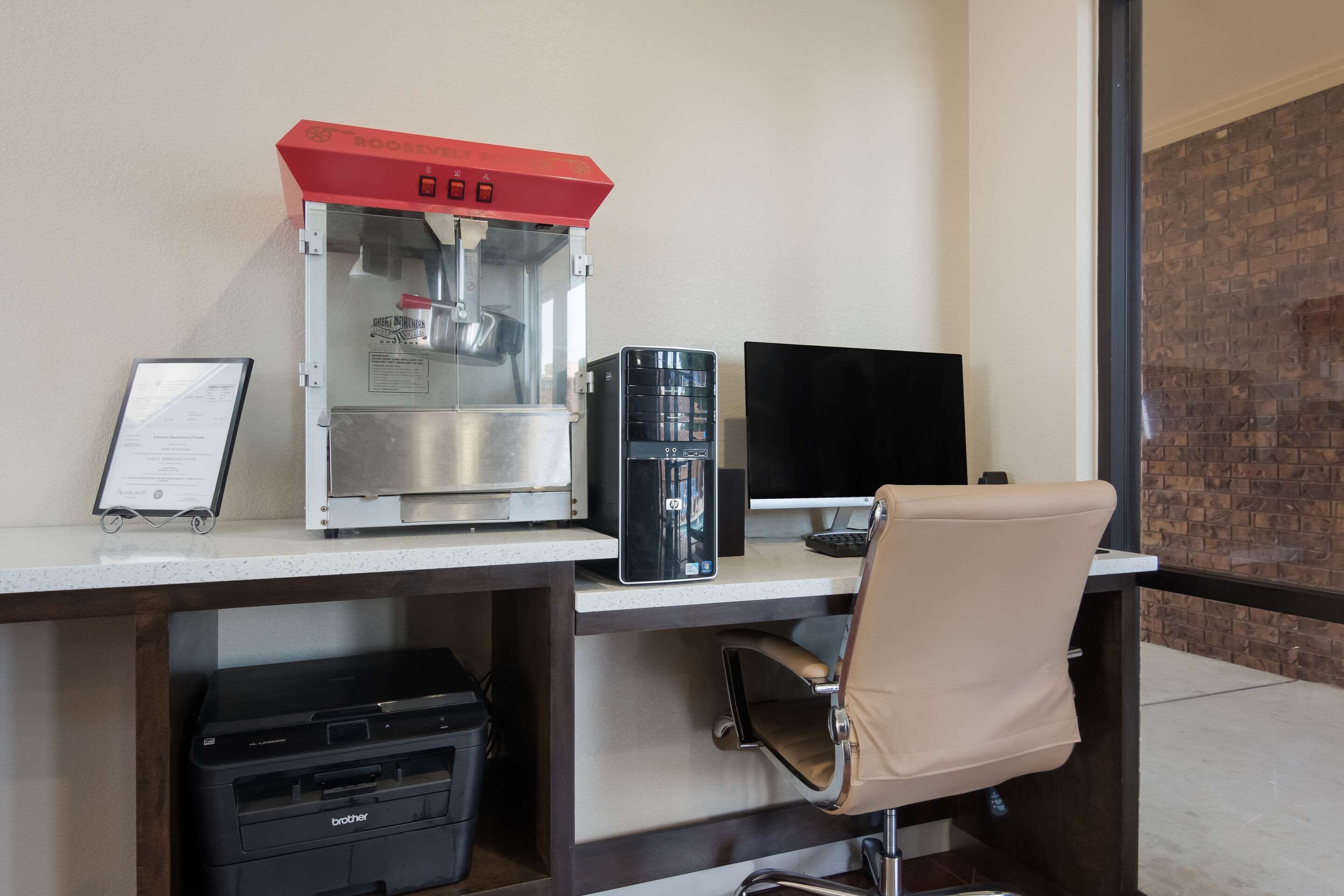 A workspace with a coffee machine, a computer, and a printer.