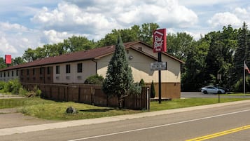 Un hotel Red Roof Inn con un cartel que indica desayuno y Wi-Fi gratuito para tarifas AAA para personas mayores.