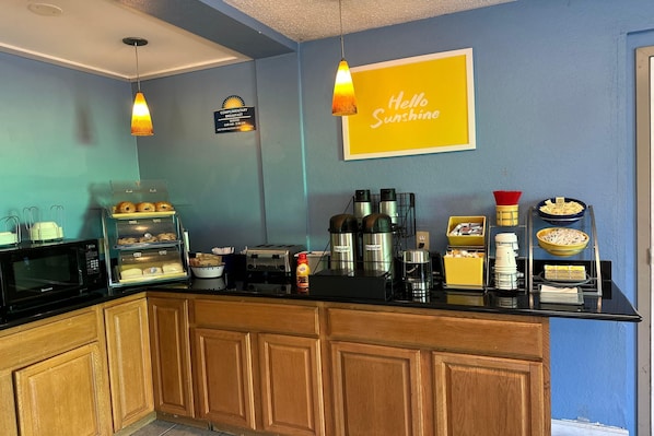 A breakfast bar with a coffee machine, toaster, and various food items.