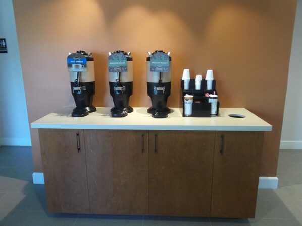 A coffee station with three coffee machines and a sugar dispenser. - Good Nite Inn - Calabasas (Agoura Hills)