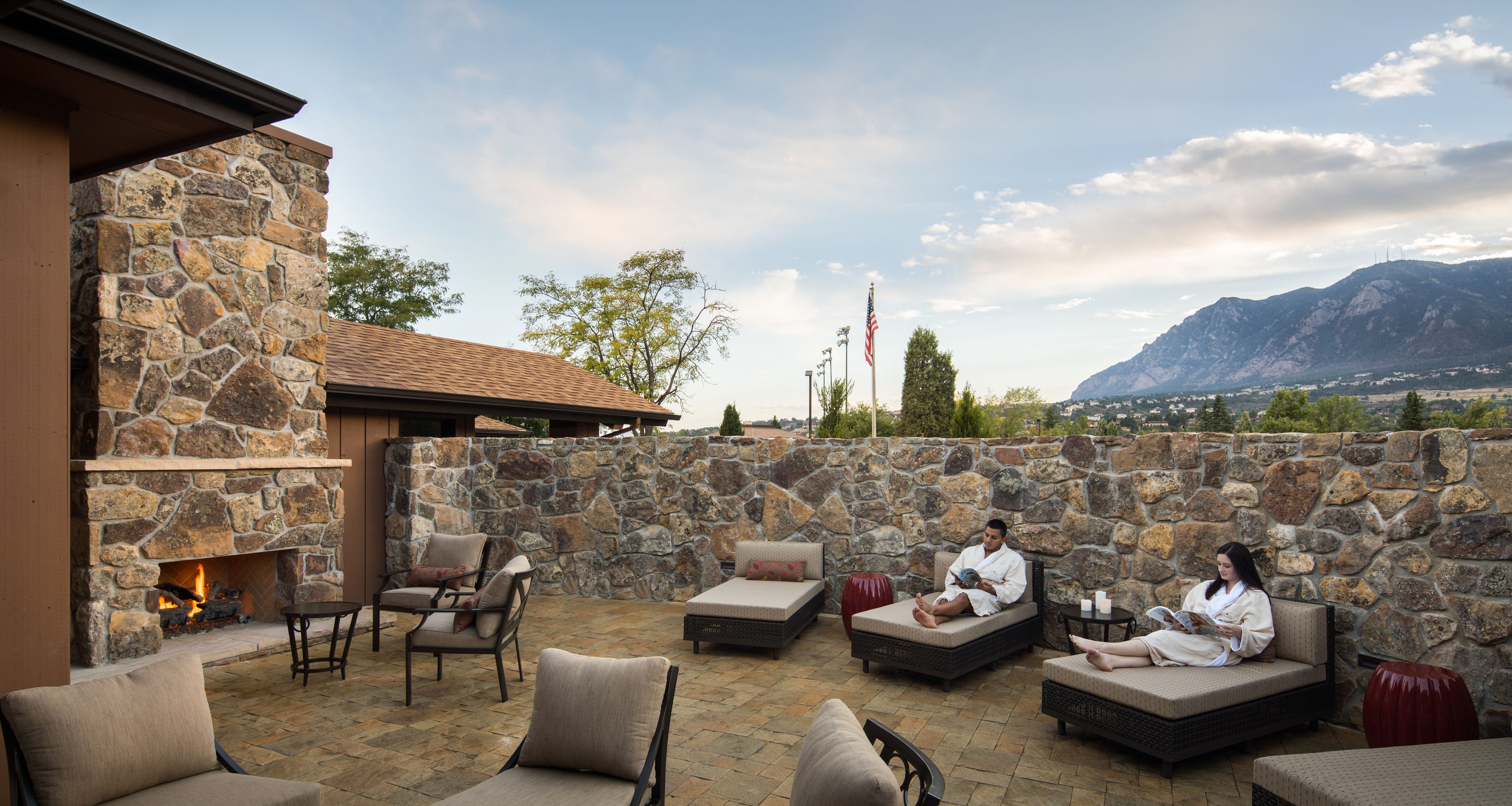 Une terrasse en pierre avec des sièges extérieurs, une cheminée et une vue sur les montagnes.