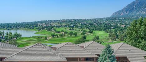 Un hôtel doté de nombreux balcons donnant sur un terrain de golf et un lac.