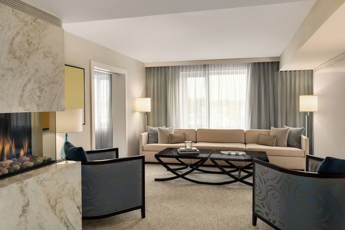 A modern living room with a marble fireplace, a sofa set, and a coffee table.