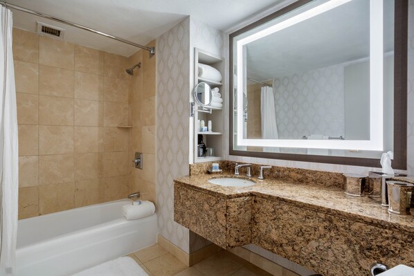 A modern bathroom with a bathtub, a large mirror, and a granite countertop. - Omni New Haven Hotel at Yale (New Haven)