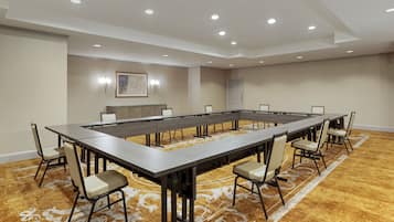 A conference room with a long table, chairs, and recessed lighting.