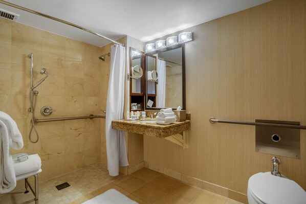 Un baño moderno con ducha a ras de suelo, tocador con espejo y retrete.