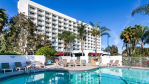 A hotel with a swimming pool, sun loungers, and palm trees. - Motel 6 Los Angeles, CA - Los Angeles - LAX (Inglewood)