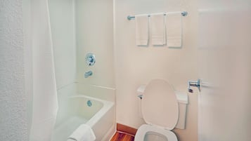 Ein Badezimmer mit Badewanne, Toilette und Handtuchhalter.