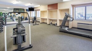 A gym with cardio equipment, weight machines, and a treadmill.