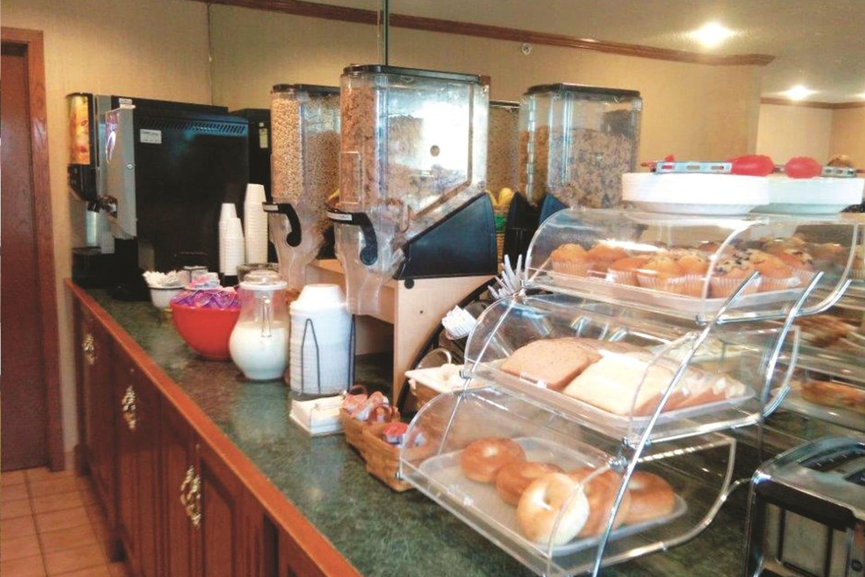 Ein Buffet mit verschiedenen Speisen, einer Kaffeemaschine und einem Kühlschrank.