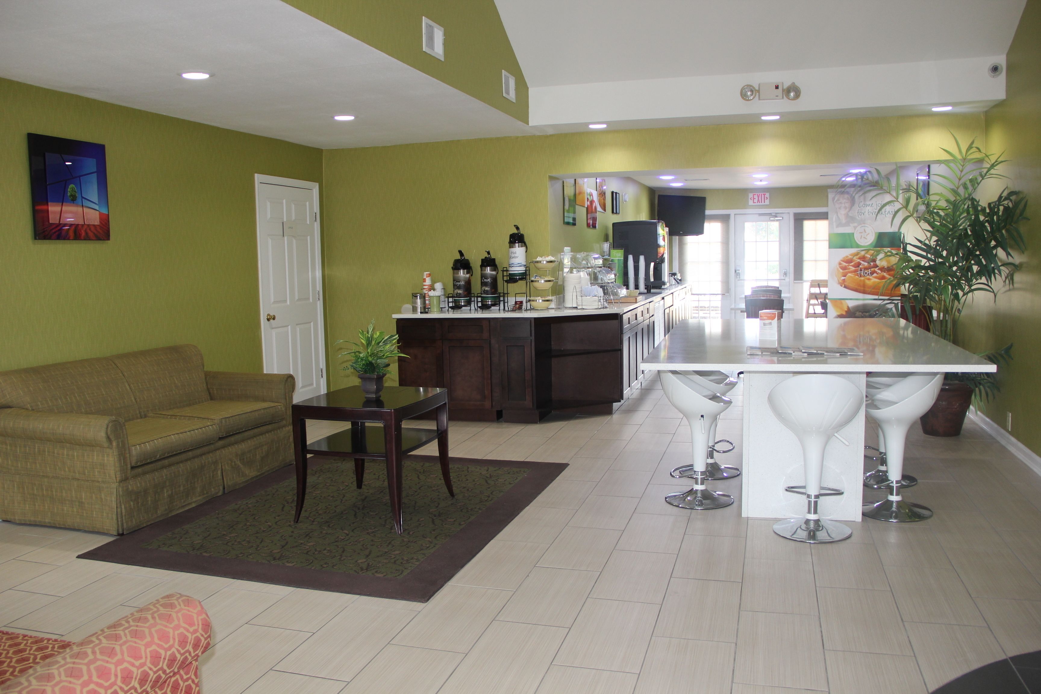 A modern living room with a sofa, a coffee table, and a dining area with bar stools.