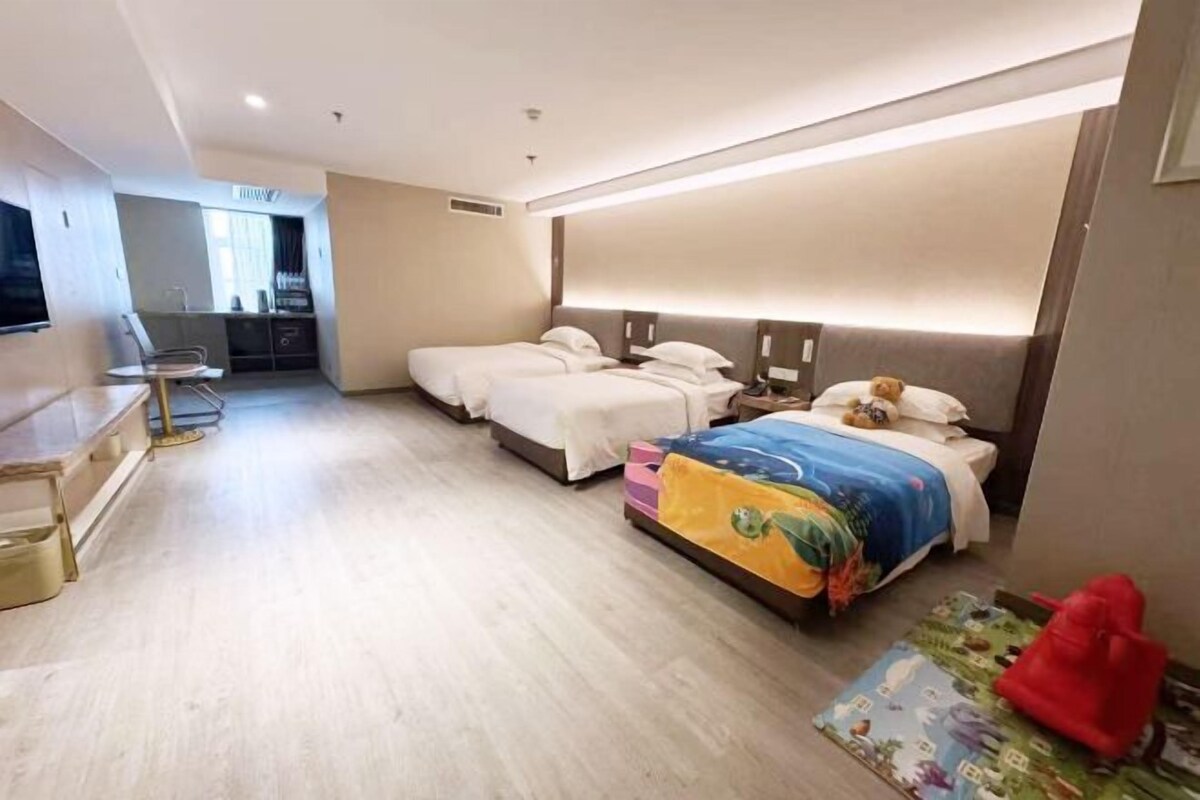 Habitación de hotel con dos camas, un escritorio y una kitchenette.