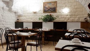 A restaurant with white brick walls, wooden tables, and black chairs. - Bristol République (Paris)
