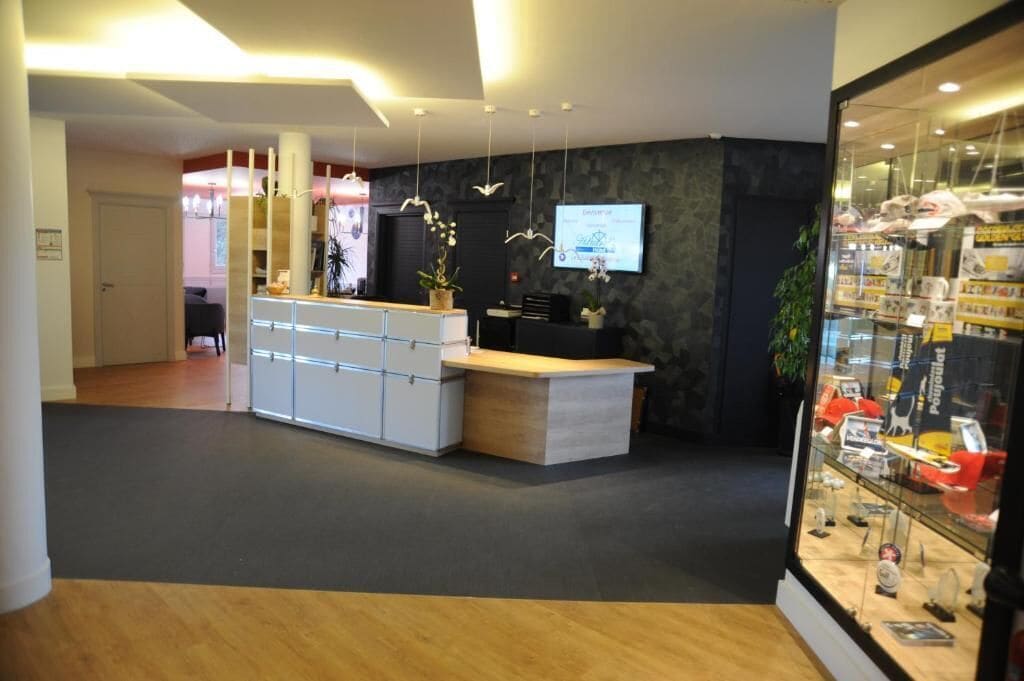 Een receptiebalie, een zithoek en een vitrine met spullen.