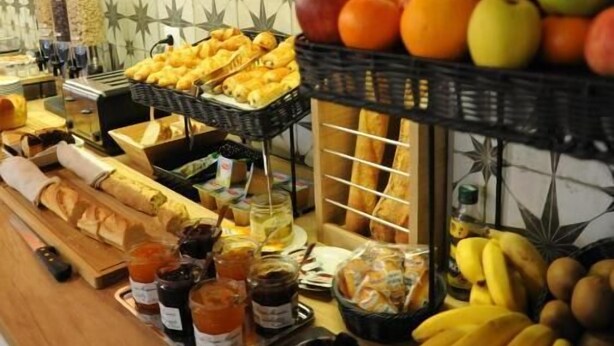 Een buffet met verschillende soorten fruit, gebak en sauzen.