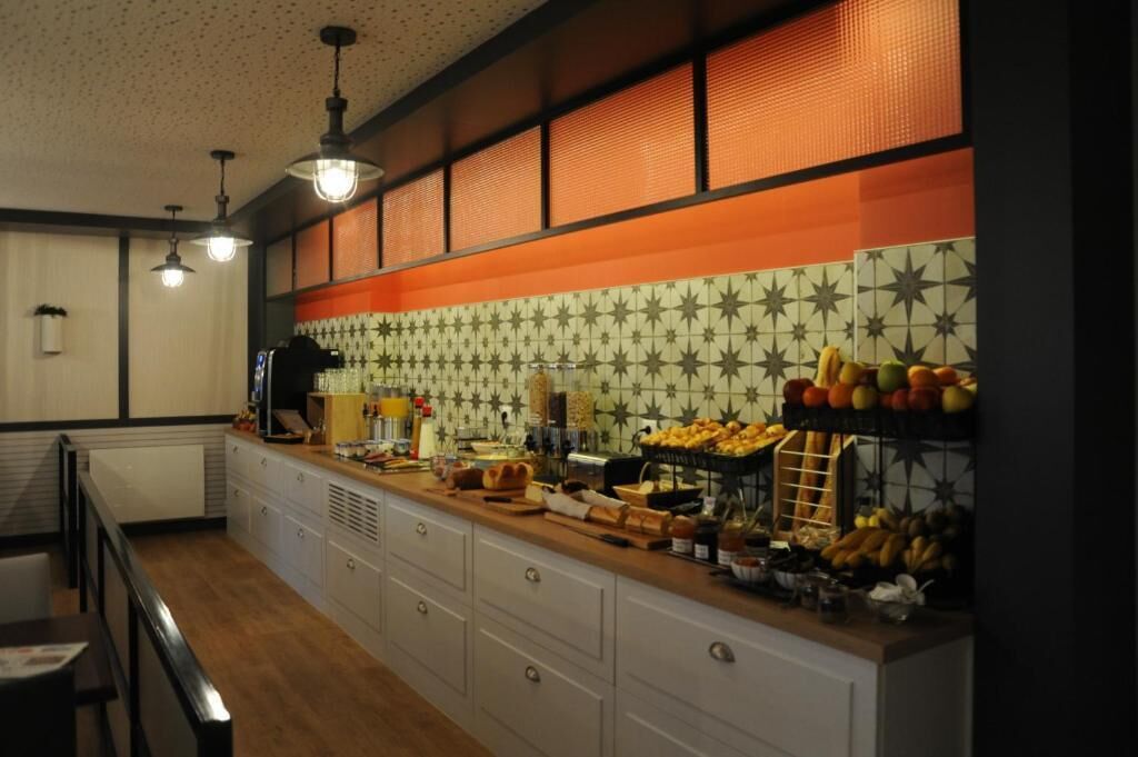 Una cocina con una encimera larga, diferentes alimentos y un salpicadero decorativo.