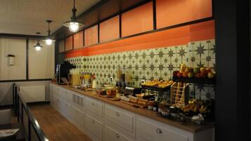 Una cocina con una encimera larga, diferentes alimentos y un salpicadero decorativo.