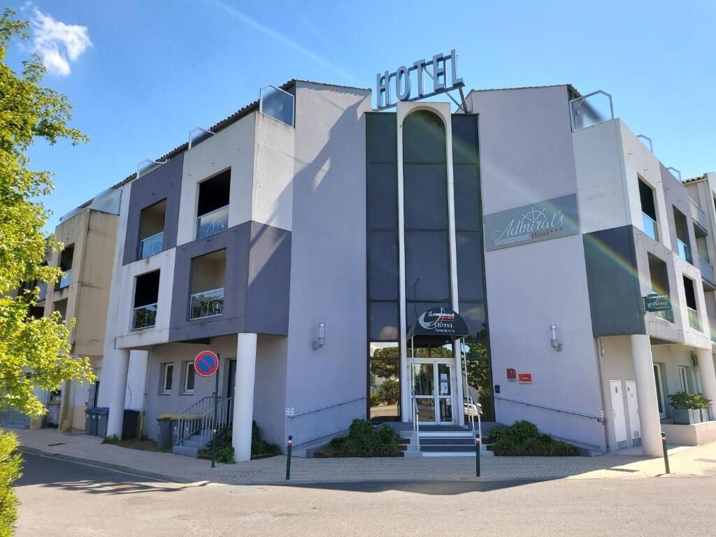 En moderne hotelbygning med et tydeligt skilt, hvor der står 'HOTEL' øverst.
